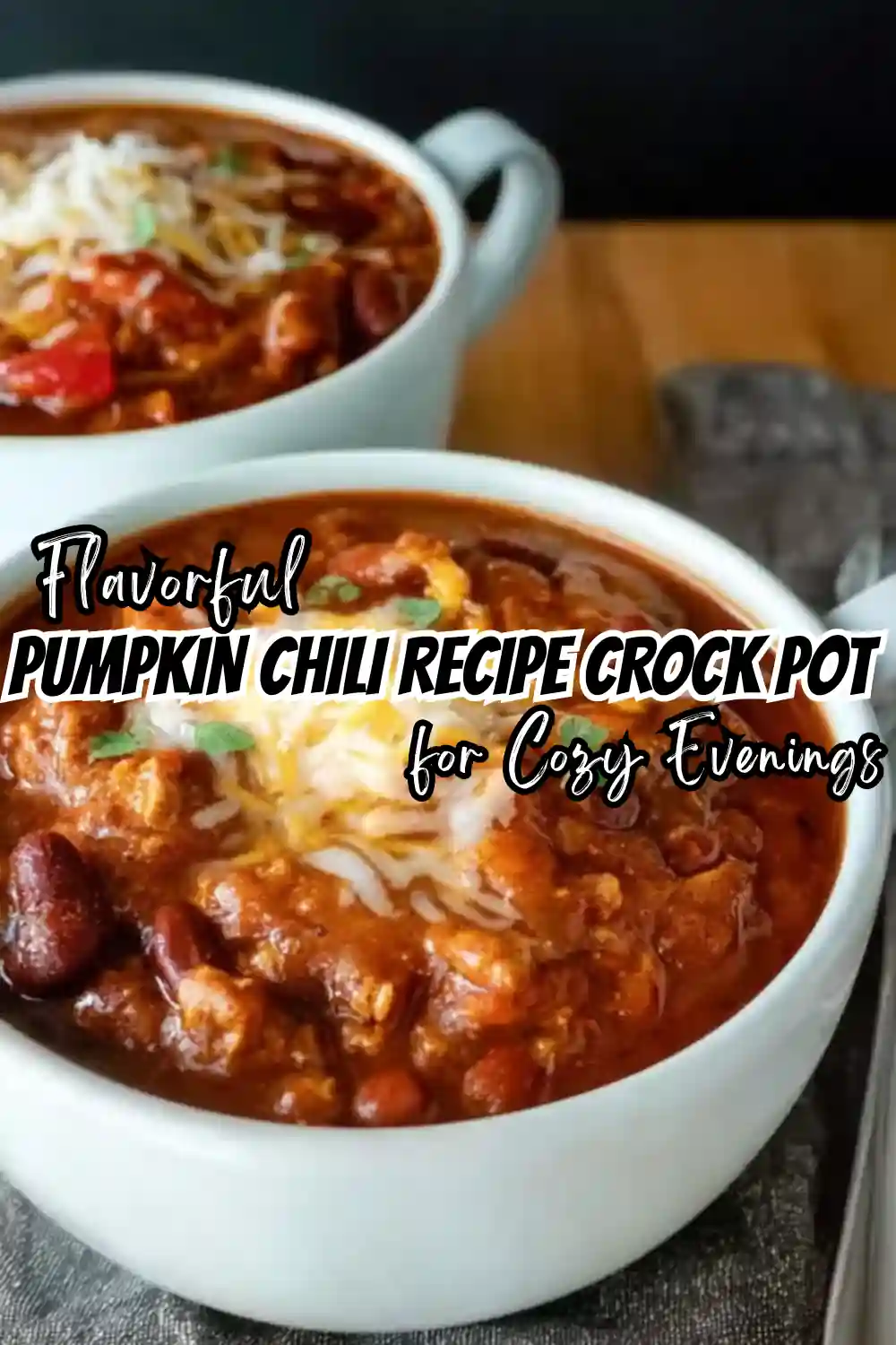 flavorful pumpkin chili in white bowls with cheese and beans