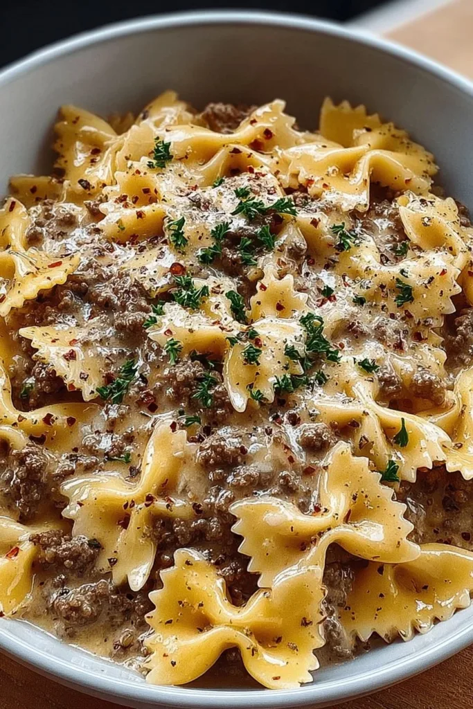 Creamy Parmesan Garlic Beef Bowtie Pasta in a bowl, garnished with parsley