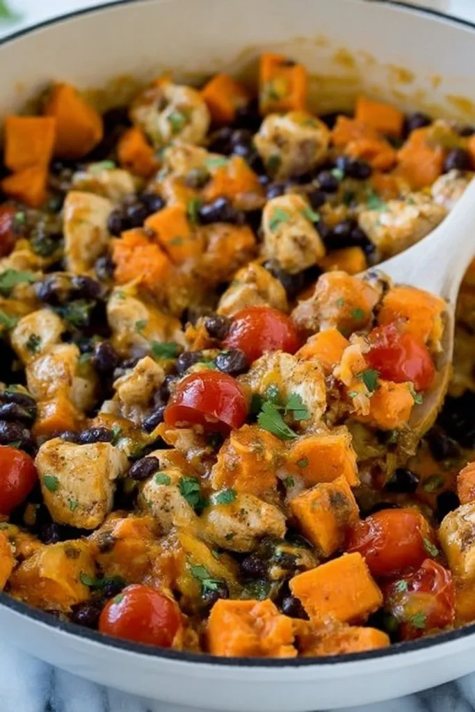 Mexican-Style Chicken with Sweet Potatoes and Black Beans in a skillet