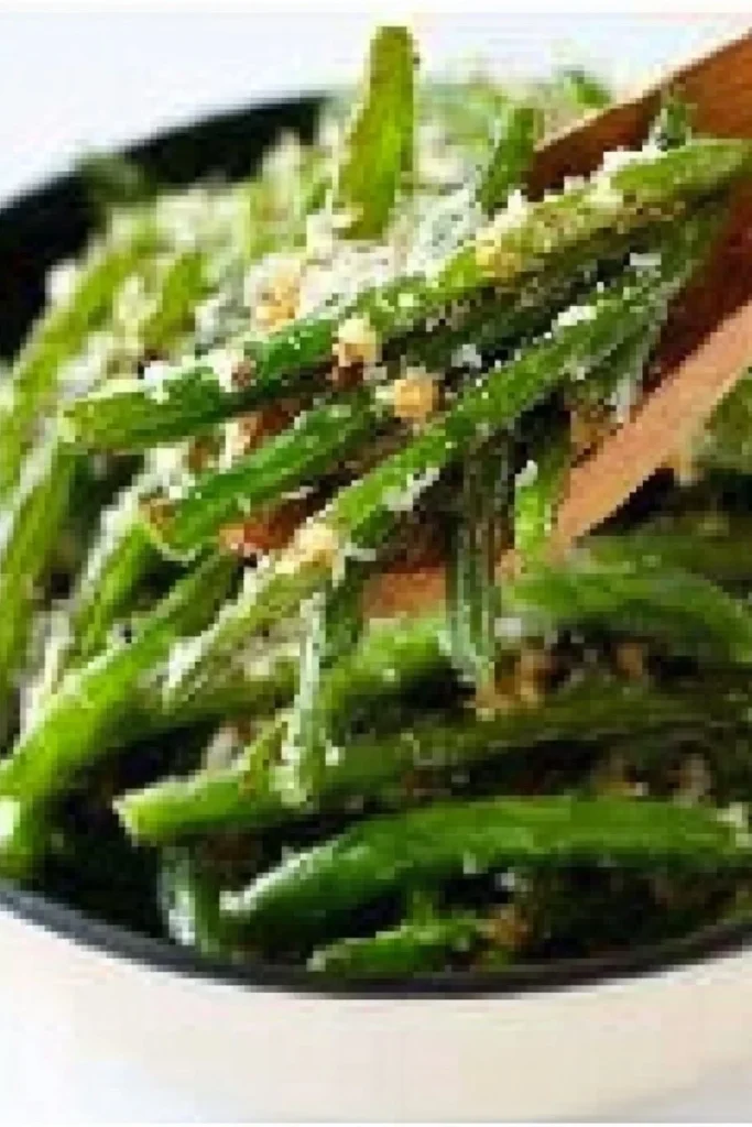 Plate of roasted green beans topped with Parmesan cheese