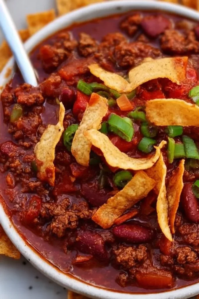 Bowl of best darn chili topped with cheese and cilantro.