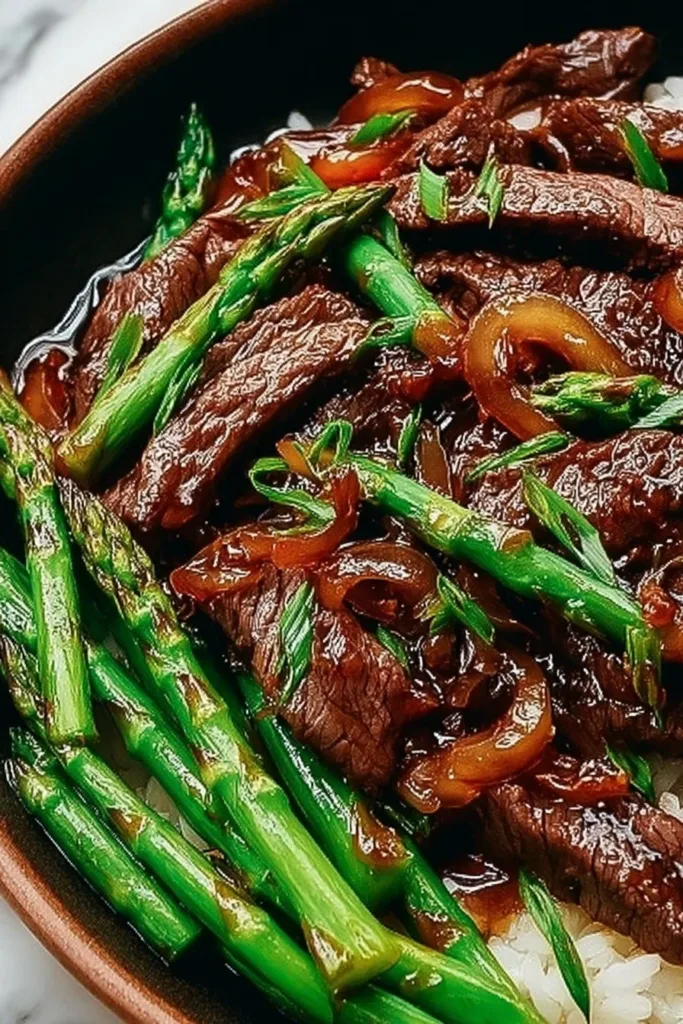 A bowl of simple beef with oyster sauce served with vegetables and rice.