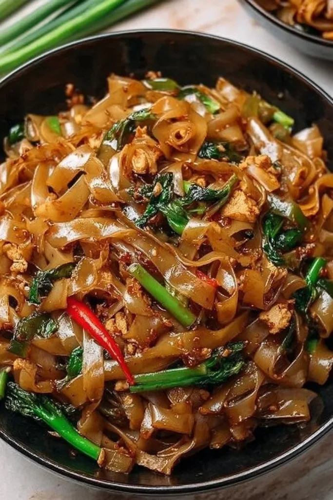Plate of Street Style Thai Drunken Noodles with vibrant vegetables and sauce