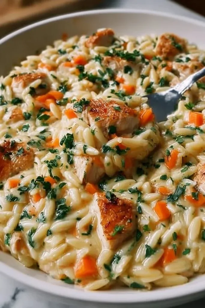 Creamy chicken pot pie orzo dish with vegetables and a flaky crust