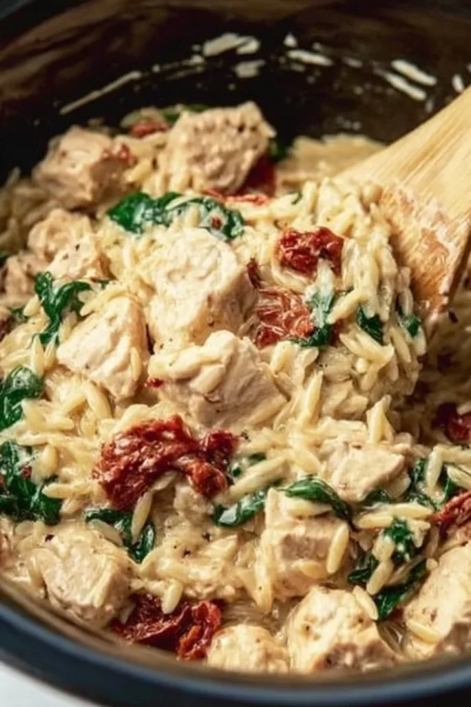 Crock Pot Marry Me Chicken Orzo served with fresh herbs on a plate.
