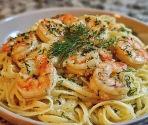 Plate of Lemon Dill Garlic Shrimp Pasta with herbs and lemon wedges