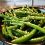 Plate of delicious easy garlic butter green beans garnished with herbs.