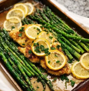 One pan lemon parmesan chicken with asparagus on a plate.