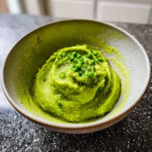 Delicious homemade pea puree served in a bowl garnished with herbs
