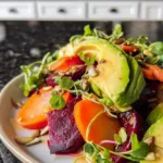 Roasted beet and carrot salad with avocado in a bowl.