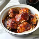Crockpot BBQ chicken thighs served with tangy sauce