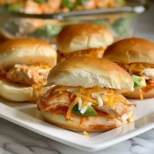 Crock-Pot Enchilada Chicken Sliders 3 Crock-Pot Enchilada Chicken Sliders served on a platter with toppings