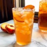 Glass of Southern Fresh Peach Sweet Tea with fresh peach slices